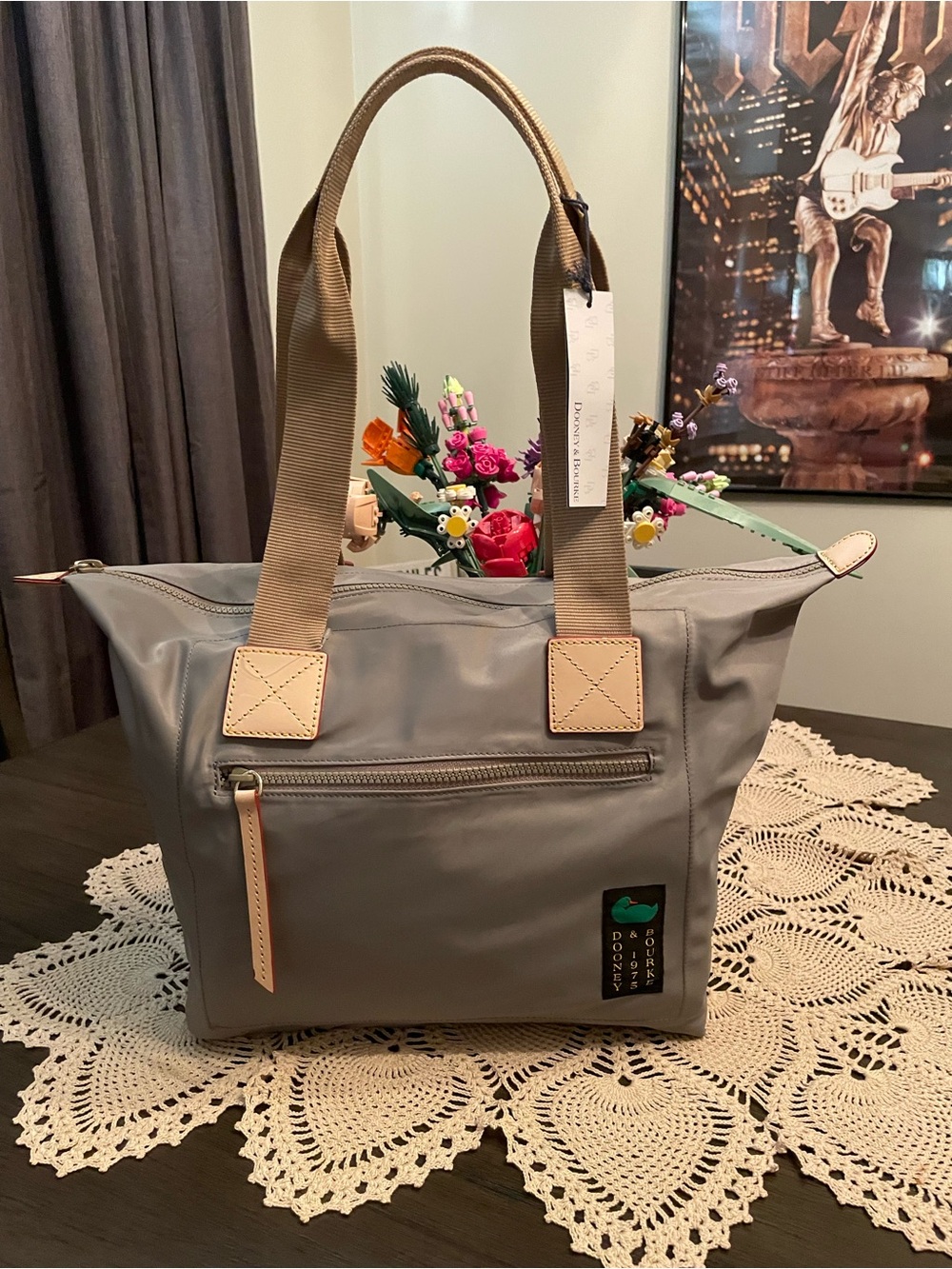 Dooney & Bourke Nylon Front Zip Tote bag with tan leather accents.